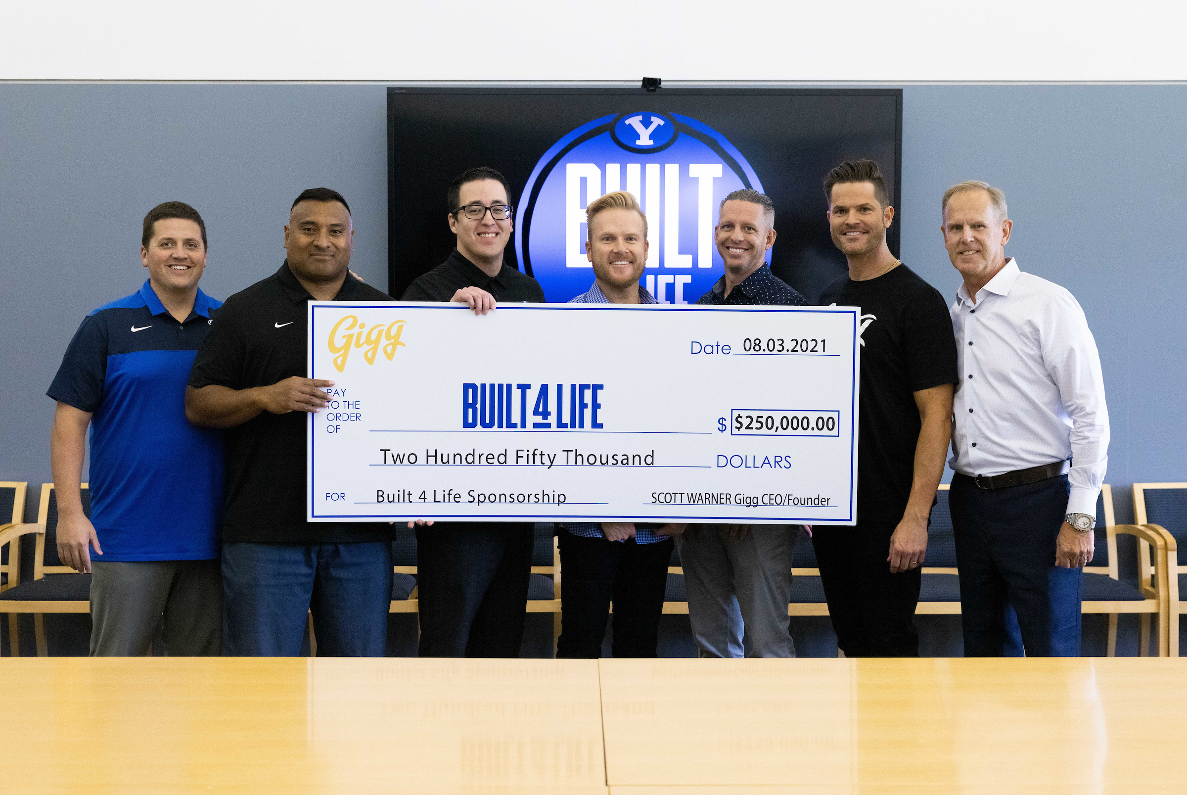 BYU and Gigg leadership holding $250,000 sponsorship check