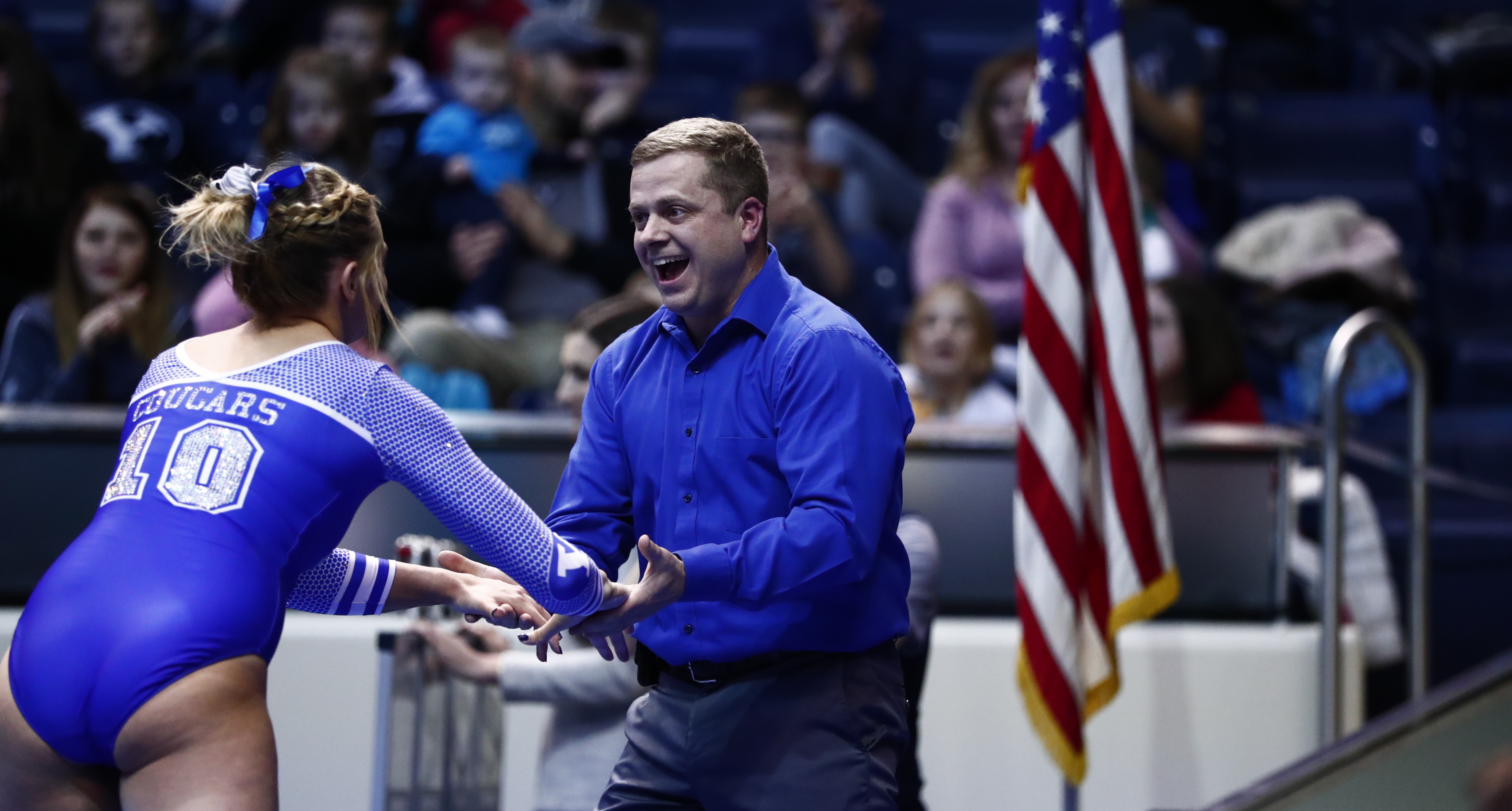 head coach Guard Young congratulates a gymnast