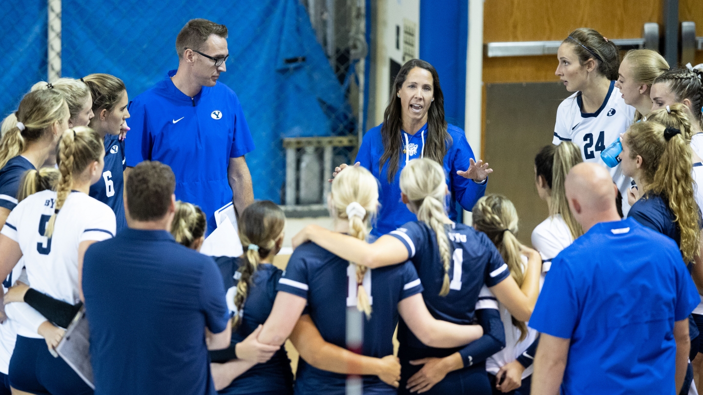 BYU women's volleyball huddles around coach olmstead who is giving instruction
