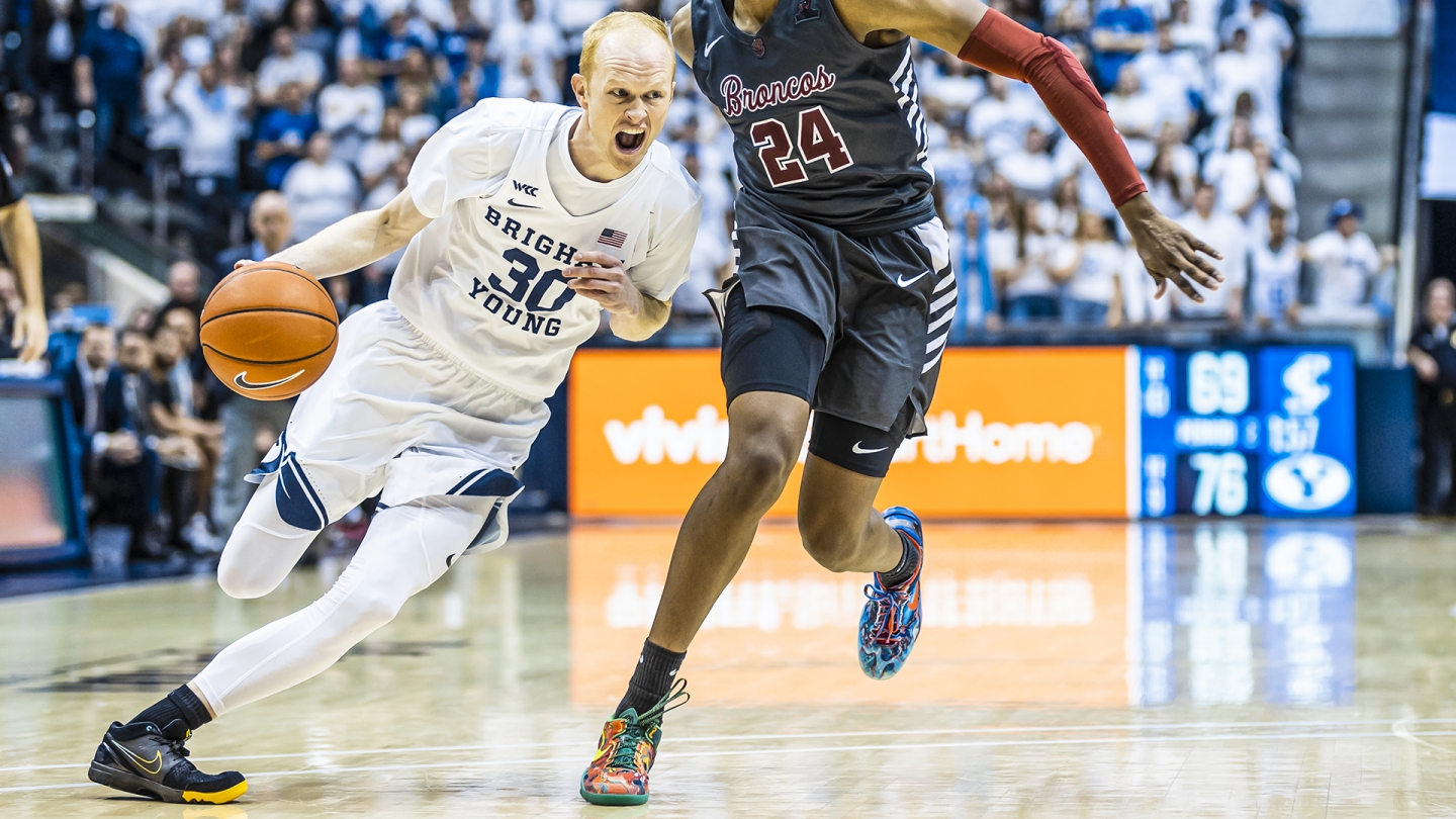 TJ Haws drives to the basket while dribbling with his right hand.