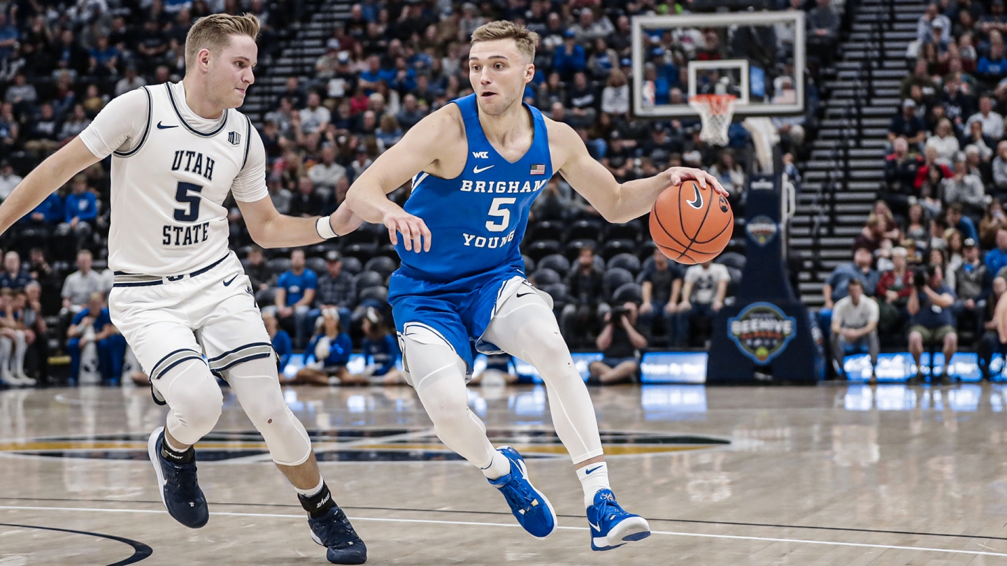 Jake Toolson handles the ball while Sam Merrill of Utah State defends in Vivint Smart Home Arena.