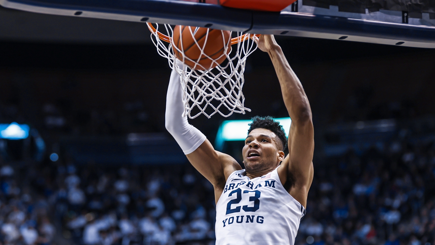 Yoeli Childs dunk the ball with two hands.