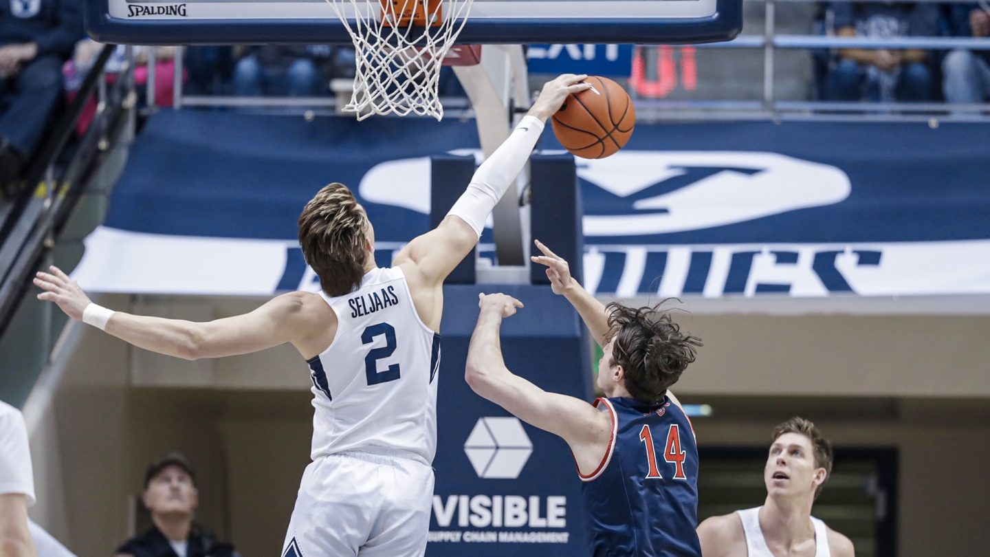 Zac Seljaas uses his right hand to block a shot by #14 from Saint Mary's.